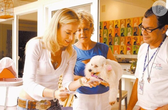 Angélica dá um confere no crachá de Belinha, a cachorra de Ana Maria Braga, durante o programa 'Estrelas', em abril de 2006