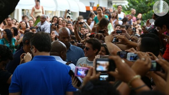 Tom Cruise é cercado por uma multidão ao sair do hotel em que está hospedado no Rio de Janeiro