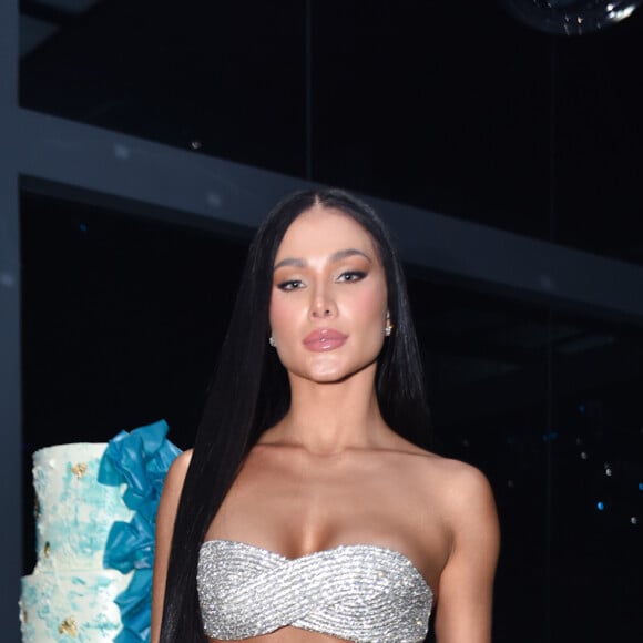 Flavia Pavanelli usou conjunto de top sem alças e saia longa, ambos brancos e com aplicações prateadas, em festa de aniversário