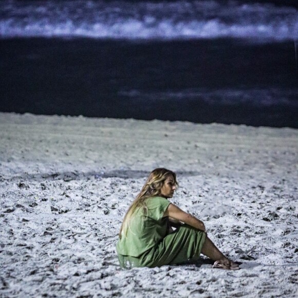 Patricia Poeta sentou na areia da praia após breve caminhada e foi clicada olhando para o mar