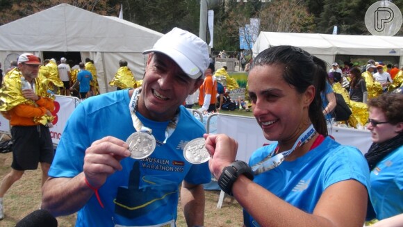 Carol Barcellos e Clayton Conservani exibem as medalhas no final da Maratona de Jerusalém