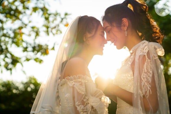 Casamento homoafetivo: Neste exemplo uma das noivas optou por usar um vestido com renda, tomara que caia e véu. Já a outra noiva optou por um vestido com alço e até mesmo uma capa transparente.