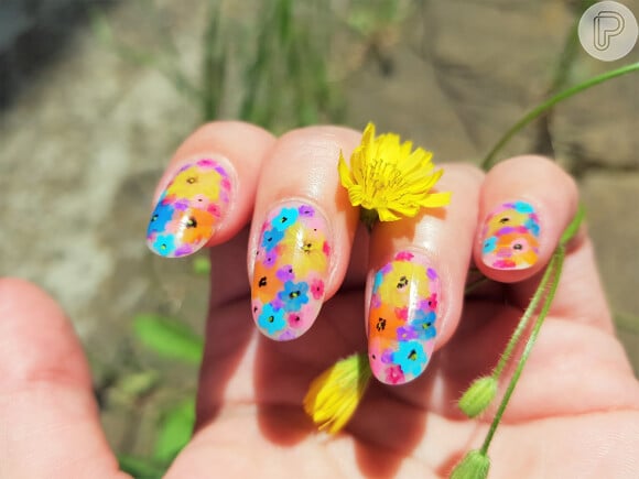 Flores multicoloridas aparecem nessa versão de nail art com unhas encapsuladas