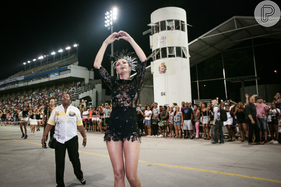 Ana Hickmann faz coraçãozinho para a plateia que estava nas arquibancadas do sambódromo de São Paulo