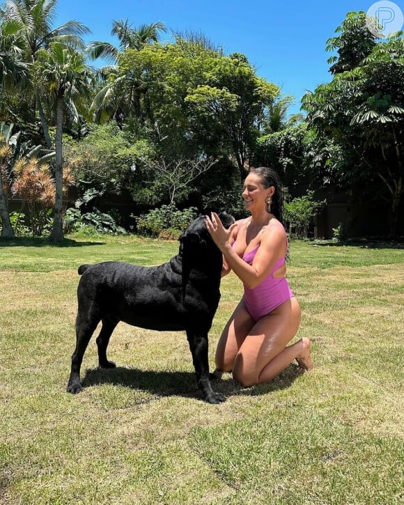 Usando um maiô rosa, Paolla Oliveira surgiu mostrando os pernões ao lado do cachorro Marley e ganhou elogios de fãs