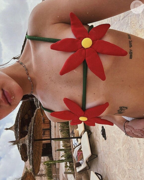 Biquíni de Mel Maia trazia uma flor vermelha grande na frente e com as alças verdes