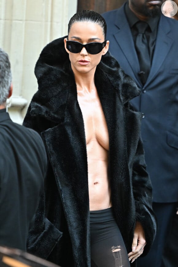 Para o desfile, Katy Perry elegeu um casaco de pelo preto e dispensou o sutiã