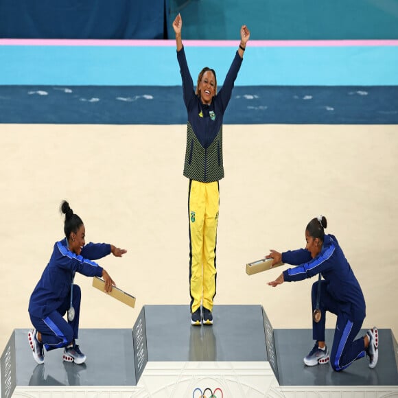 As atletas Simone Biles e Jordan Chiles se curvam à Rebeca Andrade e fazem referência durante as Olimpíadas de Paris 2024.