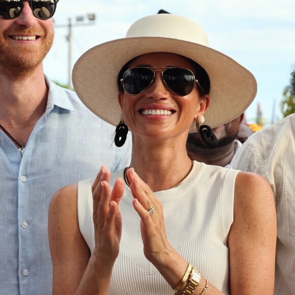 Além da camisa que é uma aposta coringa, Meghan Markle também usou um chapéu para compor a produção.