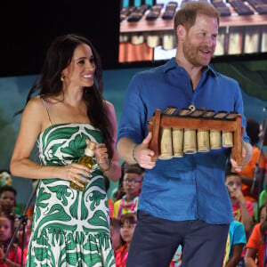 Esse outro vestido que Meghan Markle usou era com fundo claro, de estampas verdes, com alças finas.