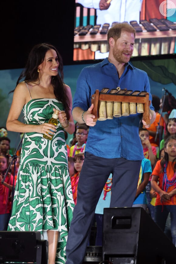 Esse outro vestido que Meghan Markle usou era com fundo claro, de estampas verdes, com alças finas.