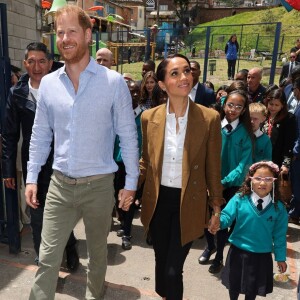 Outra proposta chique e atemporal, o blazer mais alongado, foi uma das apostas de Meghan Markle. Neste caso, ela compôs com uma blusa clara, ao fundo.