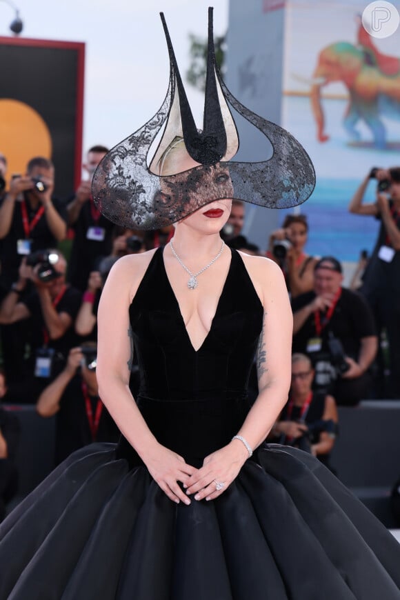 Lady Gaga, além do chapéu excêntrico, apostou num look preto nada básico, da Dior, com decote em V.