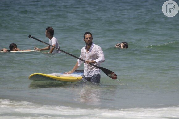 Depois de mostrar equilíbrio sobre a prancha, Rafael Cardoso também caiu no mar e deixou sua boa forma em evidência com a camisa molhada