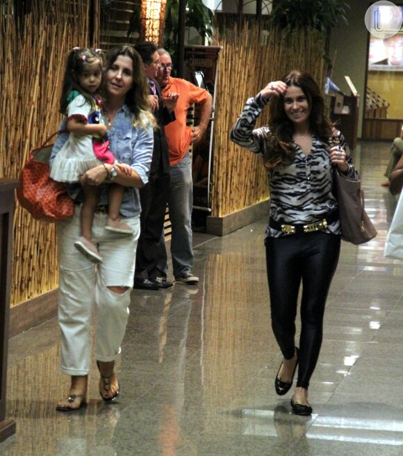 Simpática, Giovanna Antonelli ri para o paparazzo enquanto Christiane Dias carrega uma de suas gêmeas