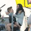 Justin Bieber segura  Selena Gomez no colo no set de filmagem de um clip do cantor.