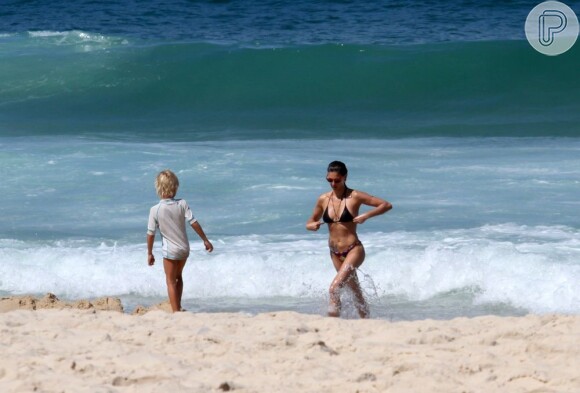 João observa a mãe, Fernanda Lima, saindo do mar