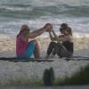 Letícia Spiller faz abdominais acompanhada de uma outra aluna na praia