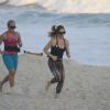 A atriz tira a tarde de folga nas gravações de 'Salve Jorge' para fazer exercício de força na praia