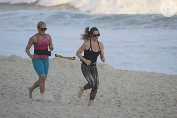 A atriz tira a tarde de folga nas gravações de 'Salve Jorge' para fazer exercício de força na praia