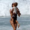 A apresentadora beijo o filho após mergulho na praia