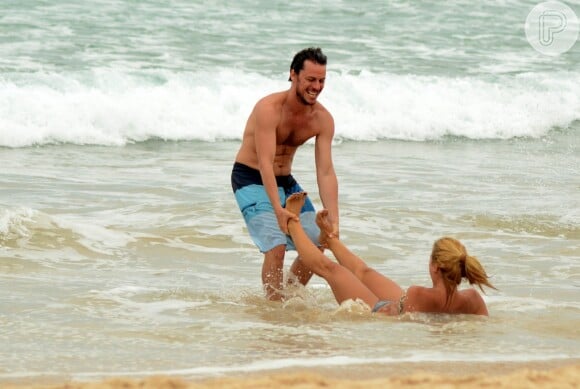 Carolina Dieckmann foi clicada aproveitando um dia de praia com o marido, Tiago Worcman, no Rio. Na foto, atriz é arrastada pelo maridão em uma brincadeira do casal