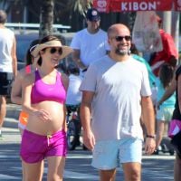 Na reta final da gravidez, Mariana Gross caminha com o marido em praia do Rio