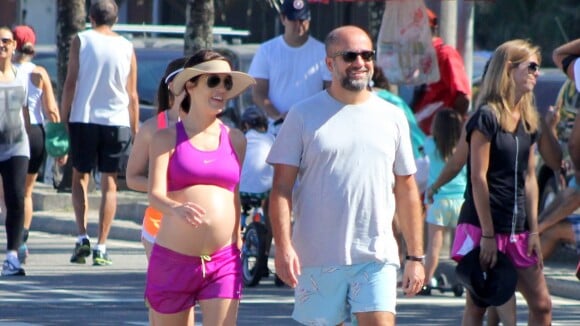 Na reta final da gravidez, Mariana Gross caminha com o marido em praia do Rio