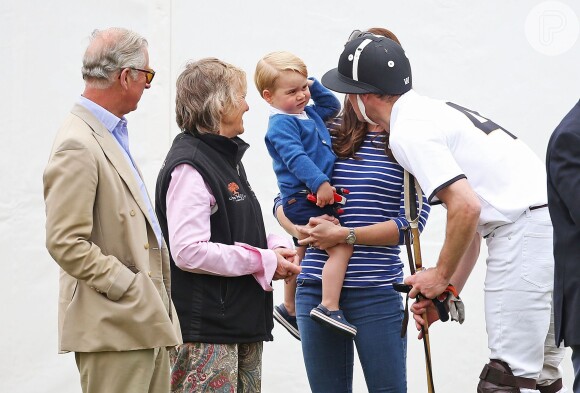 Príncipe William paparica o filho, George, no colo da  mulher, Kate Middleton, em jogo beneficente. O pai, Príncipe Charles, também compareceu ao evento ao lado da mulher, a duquesa Camila