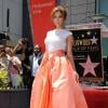 Jennifer Lopez escolheu uma saia laranja e uma camiseta branca para a confraternização da homenagem