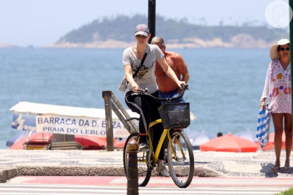 Júlia Lemmertz anda de bicicleta na orla da praia