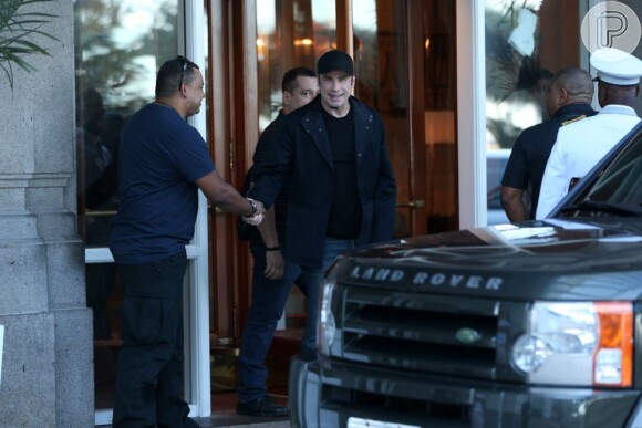 John Travolta cumprimenta um fã na porta do hotel, no Rio