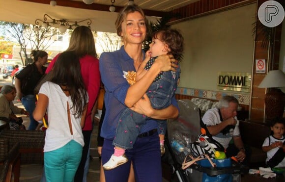 Grazi Massafera, sorridente, carrega Sophia nos braços, sua filha com Cauã Reymond