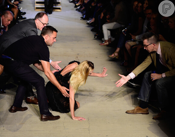 Candice Swanepoel foi ajudada prontamente por homens na primeira fila ao car durante o desfile da Givenchy na Semana de Moda de Nova York