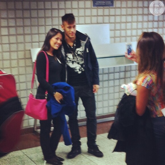 Neymar posa com uma fã na chegada ao aeroporto, antes de embarcar para Barcelona