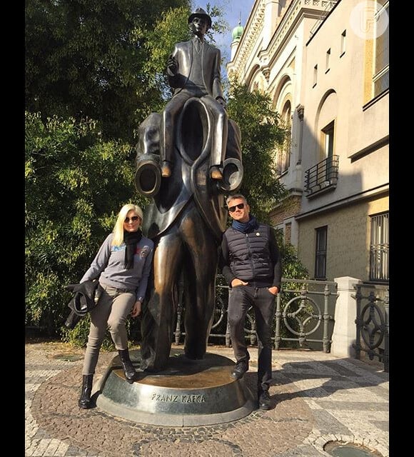 O casal tirou uma foto em frente ao monumento Franz Kafka, em Praga