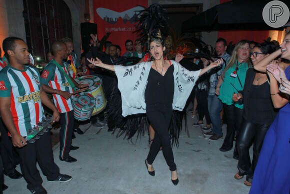 Nanda Costa se mostrou animada com a presença da bateria da escola de samba Grande Rio no lançamento do filme 'Apaixonados', no 6º dia do Festival do Rio 2015. A atriz escolheu calça, blusa e scarpins pretos, combinados a um quimono branco, para lançar o longa do qual faz parte do elenco