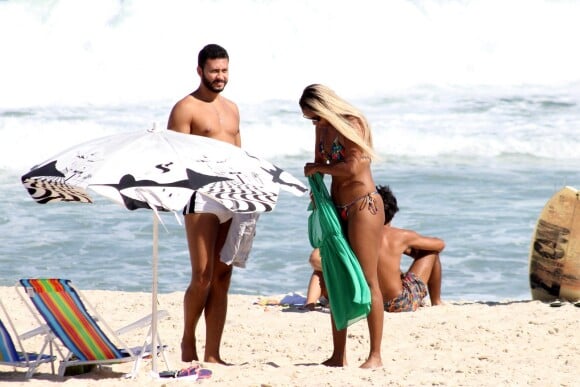 O namorado da atriz a observa enquanto ela veste a roupa para deixar a praia