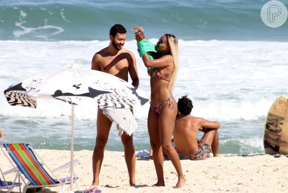 Guilherme Guimarães observa o corpão da namorada enquanto ela se veste para deixar a praia