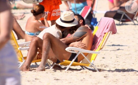Carolina Ferraz beija o namorado, o médico Marcelo Marins, na praia