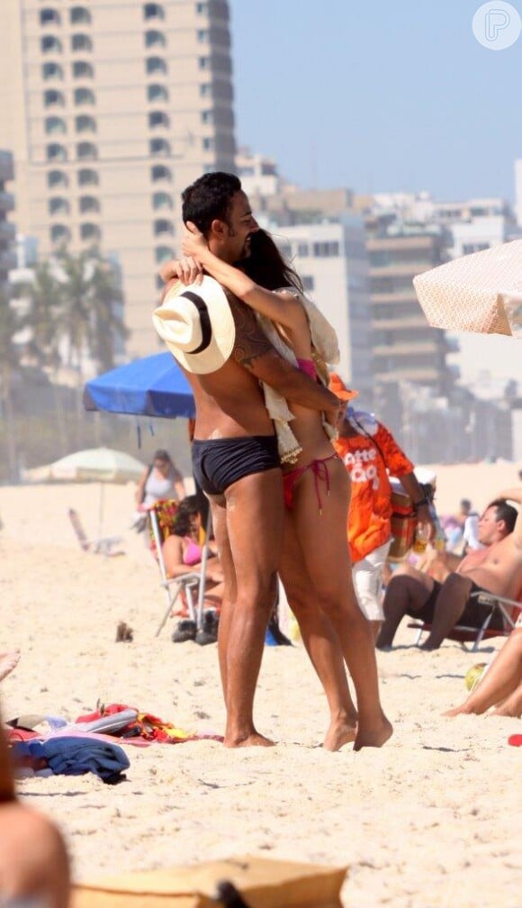 Carolina Ferraz abraça namorado na praia do Leblon, no Rio