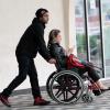 Pedro Scooby empurra a mulher, Luana Piovani, em uma cadeira de rodas