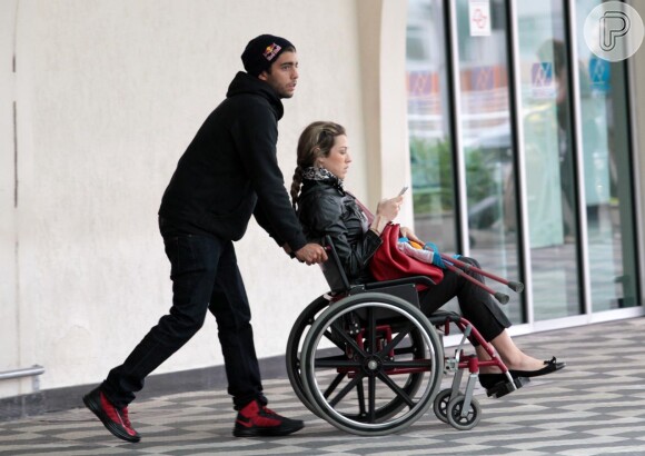 Pedro Scooby empurra a mulher, Luana Piovani, em uma cadeira de rodas