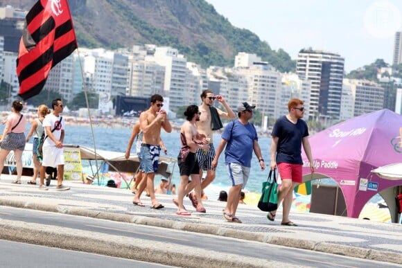 Kit Herrington se diverte com amigos ao caminhar pela orla de Copacabana