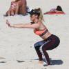 Danielle Winits malha na praia para manter o corpo em forma