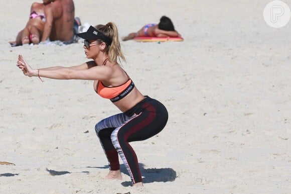 Danielle Winits malha na praia para manter o corpo em forma