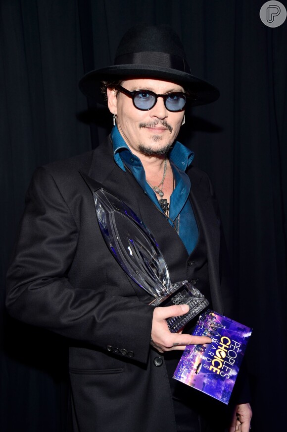 Johnny Depp foi sozinho receber seu prêmio de Melhor Ator em Filme de Drama no People's Choice Awards 2016. O ator mostrou estilo com óculos de lente azul e chapéu
