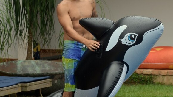 Caio Castro se refresca em piscina usando boia em formato de baleia