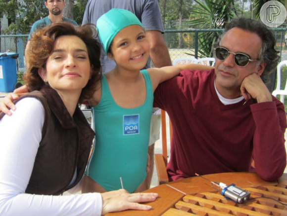 Julia Gomes posa entre os atores  Gisele Froés e Ângelo Antônio, seus pais na novela 'A Vida da Gente'
