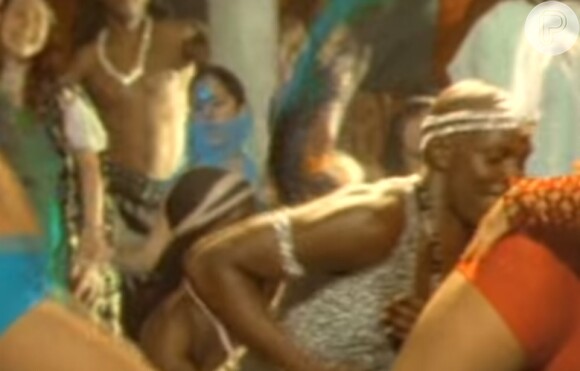 Bela Gil em cena do clipe 'Ralando o Tchan' do É o Tchan. A filha de Gilberto Gil aparece ao centro usando um véu azul